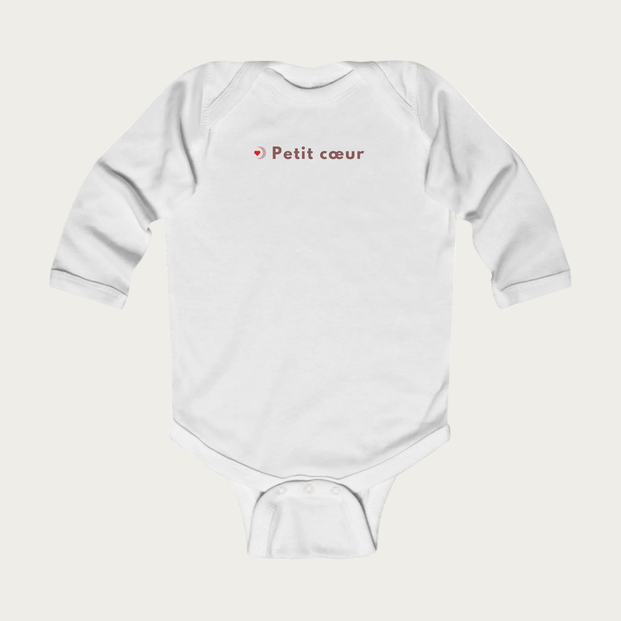 Body bébé blanc à manches longues avec l’inscription « Petit cœur », idée cadeau EVJF et mariage, photo produit sur fond clair