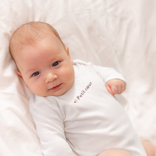 Bébé portant un body blanc « Petit cœur », idée cadeau EVJF et mariage, photo lifestyle douce sur fond clair