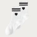 Chaussettes EVJF blanches avec coeur noir et rayures noires, accessoire elegant et tendance pour un enterrement de vie de jeune fille.