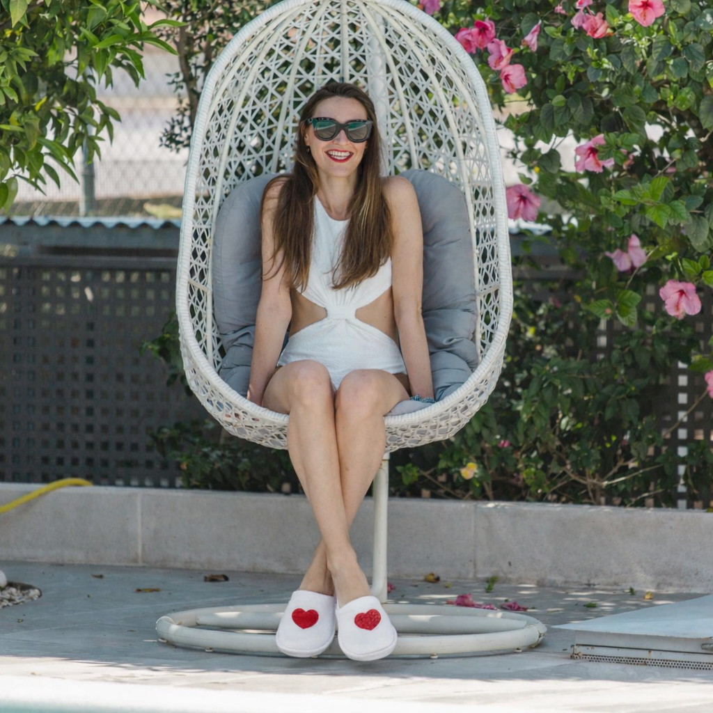Femme portant des chaussons EVJF blancs avec coeur rouge, ideale tenue detente pour enterrement de vie de jeune fille.