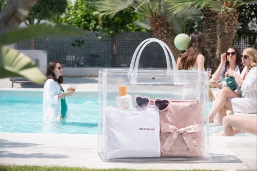 Coffret evjf demoiselle avec sac transparent tee shirt lunettes coeur et accessoires au bord de la piscine entre amies
