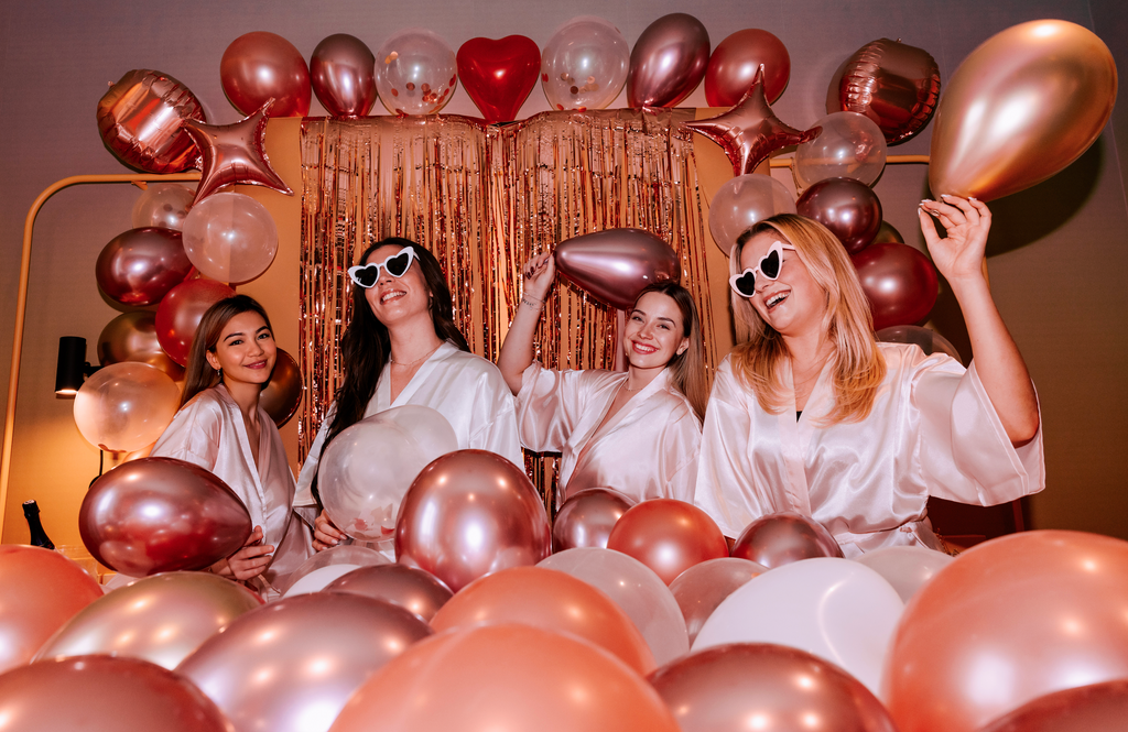 Groupe damies celebrant un EVJF avec une decoration de ballons rose gold, ambiance festive et elegante pour une soiree entre filles.
