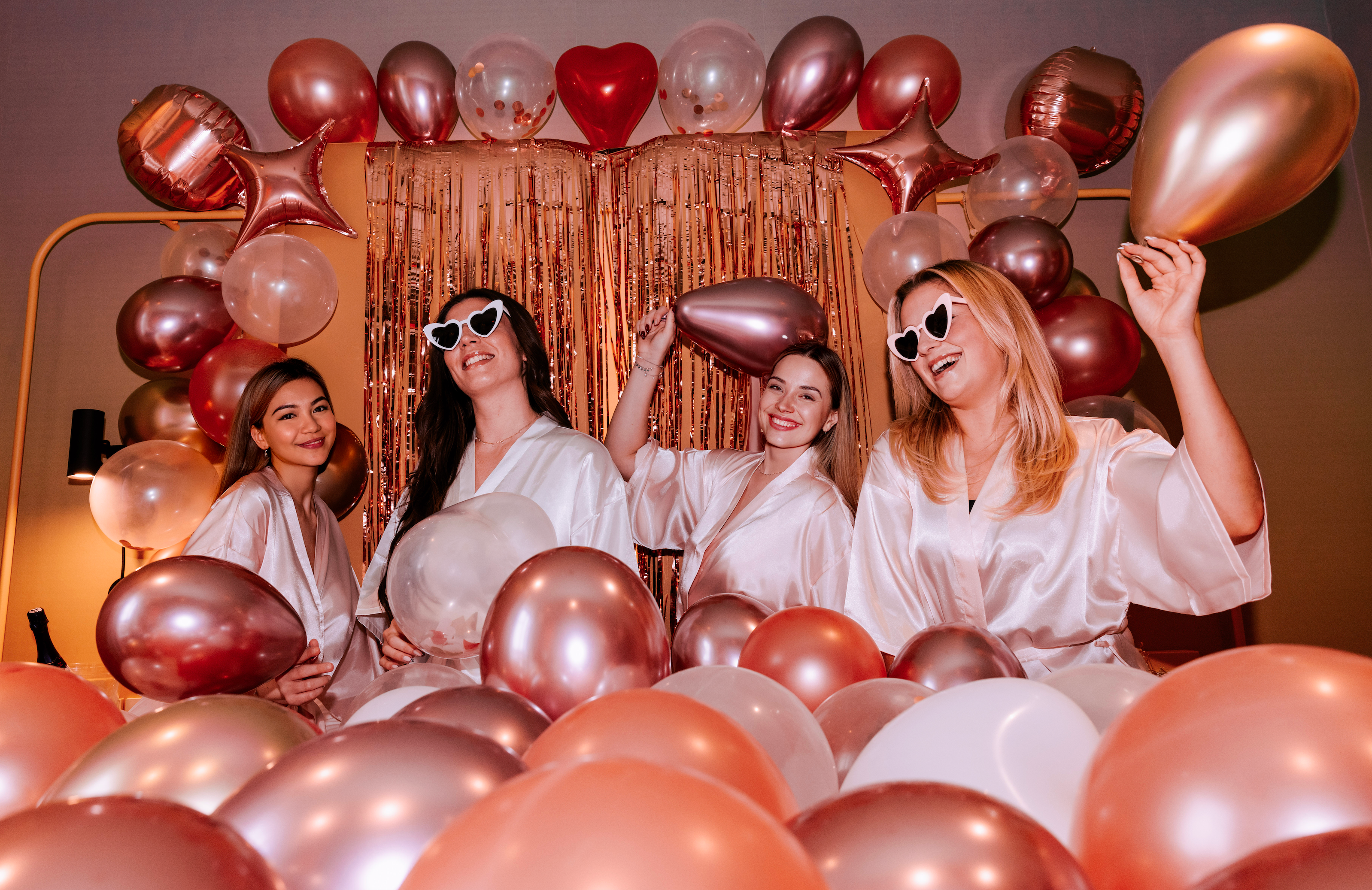 Groupe damies celebrant un EVJF avec une decoration de ballons rose gold, ambiance festive et elegante pour une soiree entre filles.