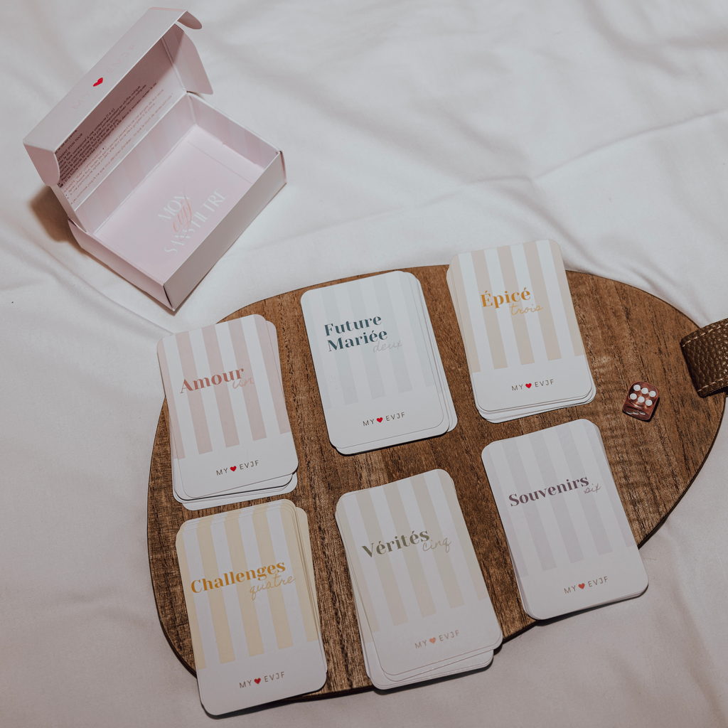 Jeu de cartes EVJF avec differents themes et defis, presente dans un coffret, ideal pour animer une soiree enterrement de vie de jeune fille.