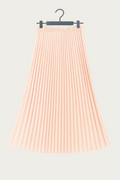 Jupe longue plissée rose pâle suspendue sur cintre, tenue fluide et élégante idéale pour un look EVJF.