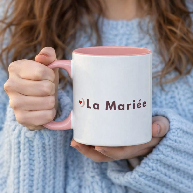 Mug EVJF blanc avec interieur et anse rose tenu a deux mains, inscription la mariee, idee cadeau pour future mariee.