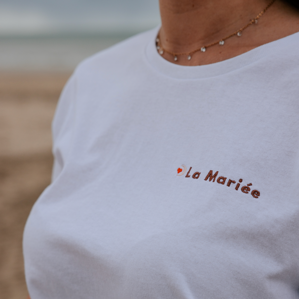 Détail de la broderie ‘La Mariée’ sur t-shirt blanc EVJF porté, finition élégante pour la future mariée.