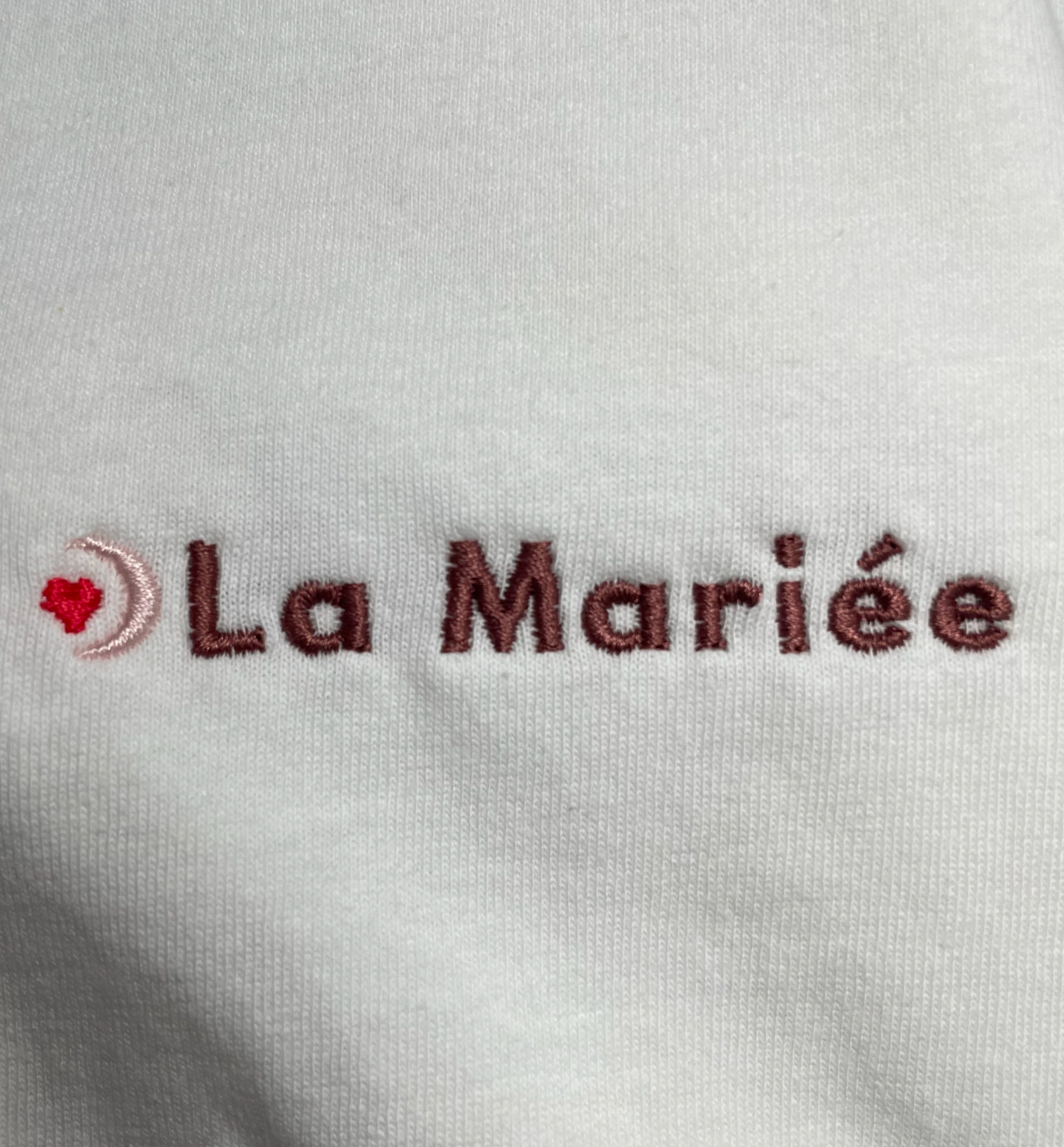 Détail de la broderie ‘La Mariée’ sur t-shirt blanc EVJF, finition brodée élégante pour la future mariée.