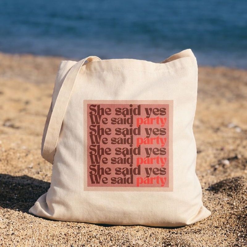 Tote bag en toile pose sur la plage avec message she said yes we said party, accessoire EVJF ideal pour une journee entre amies.