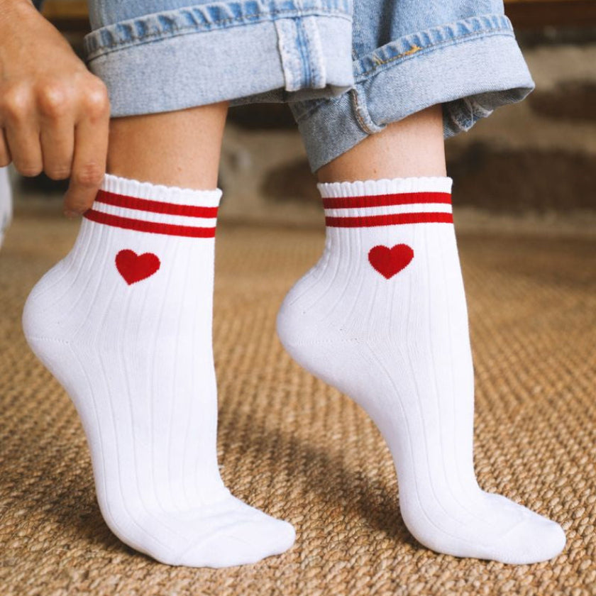 Chaussettes EVJF blanches avec cœurs rouges et rayures, accessoire original et tendance pour un enterrement de vie de jeune fille.
