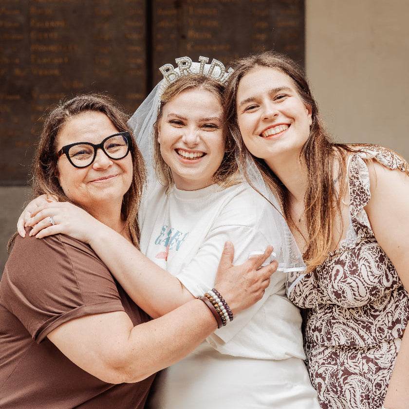 Future mariee portant un voile bride entouree de proches lors dun enterrement de vie de jeune fille, moment emotion et partage.